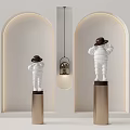 White Sculptures Wearing Hats Standing On Gold Pillars With Arched Background Walls And Hanging Lamp