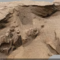 Natural Sandy Terrain With Weathered Wavy Rock Formations And Eroded Surface Features