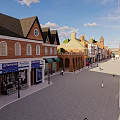 Historic Commercial Street with Red Brick Buildings Spire Towers Pedestrians Shops and Outdoor Seating