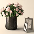 Dark Metallic Vase With Pink Roses And Green Leaves Alongside Silver Framed Butterfly