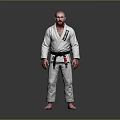 Man in White Judo Uniform with Black Belt Standing Against Gray Background