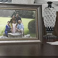 Classic Photo Frame With Family Photo On Wooden Tabletop And Crystal Lamp