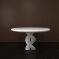 Round White Dining Table With Unique Twisted Base Against Dark Wooden Wall And Black Floor
