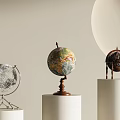 Colored And Silver Decorative Globes Displayed On White Cylindrical Pedestals With Wooden And Metal Stands