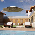 Stone And Wooden Boutique Villa Exterior With Swimming Pool Lounge Chairs And Umbrella