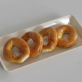 Freshly Baked Four Golden Brown Bagels on a White Rectangular Plate 3d model