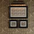 Abstract Paintings Framed in Black Hanging on Patterned Wallpaper with Overhead Lighting