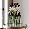 Glass Vase with Purple and White Calla Lilies on Round Metal Table with Natural Light