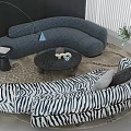 Curved Gray and Zebra Print Sofa Set with Round Coffee Table and Plant
