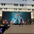 Outdoor Evening Stage With Metal Truss Lighting LED Screen Band Neon Decorations And Grass Background