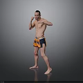 Shirtless Man Practicing Boxing Stance In Orange And Blue Shorts Against Gray Background