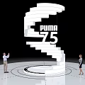 Spiral White Art Installation Featuring PUMA 75 with People Watching on Black Background Circular Floor