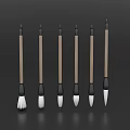 Six Wooden Handle Writing Brushes with Various Tip Shapes on Dark Background