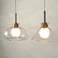 Lit Pendant Lights With Transparent Glass Shades Wooden Tops And Metal Rods Against Gray Wall