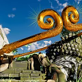 Intricate Golden Spiral Sculpture With Green Plants And Dark Round Fruits