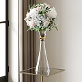 Clear Glass Vase With Golden Accent Holding White Pink Blooms Green Leaves On Metal Table