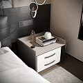 Bedside Table With Drawers And Stack Of Books On Light Top Near Black Leather Headboard
