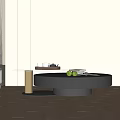 Modern Round Black Coffee Table With Gold Base And Green Apples On Wooden Floor