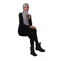 Woman in Black Dress With White Hijab Sitting and Gesturing Against Dark Background