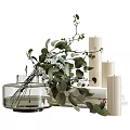 Transparent Glass Vase With White Flowers And Green Leaves Next To White Candles And Books