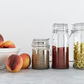 Airtight Glass Spice Jars Holding Spices on Kitchen Countertop by Fresh Peaches in White Bowl