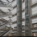 Shopping Mall Lobby With Glass Elevator Staircases And Modern Lighting Design