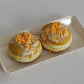 Two Glazed Doughnuts on Light Colored Rectangular Plate with Orange Crumbs Topping