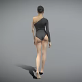 Woman in One Shoulder Bodysuit Standing Barefoot Against Gray Background