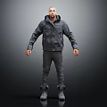 Man In Dark Hooded Jacket And Pants Standing On Gray Background With Boots