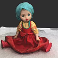 Traditional Doll With Blue Turban Yellow Blouse And Red Dress Sitting On White Surface