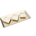 Three Layered Pastry Squares Topped with White Icing Served on Beige Rectangular Tray