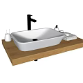 White Washbasin on Wooden Countertop with Faucet Small Bottles and Towel Against Black Tiled Wall