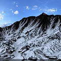Scenic Snowy Mountain Peak Landscape With Blue Sky And White Clouds