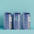Three Blue Canned Beverage Cans With Patterns And Text On Light Blue Background