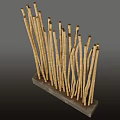Stone and Wood Art Installation with Slender Vertical Wooden Sticks on Stone Base