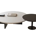 Modern Round Coffee Table With Light Wood Surface And Black Small Accent Table Featuring Books
