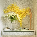 Vase with White Tulips and Yellow Branches on Marble Console Table Against Patterned Wallpaper