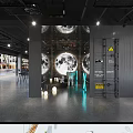 Industrial Style Restaurant Interior With Gray Walls Dining Tables Chairs Shelves And Lighting Fixtures