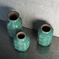 Three Green Ceramic Vases With Geometric Patterns On Dark Tabletop Against Gray Wall 3d model