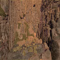 Natural Rocky Crevice Between Rugged Rock Walls With Green Moss And Scattered Stones