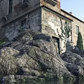 Ancient European Architecture with Stone Walls Balconies Windows Stone Steps Surrounding Rocks and Trees