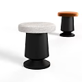 Two modern stools with round white and brown upholstered seats and black cylindrical bases