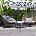 Rattan Outdoor Sofa Set With Cushions Umbrella And Green Plants On Wooden Deck