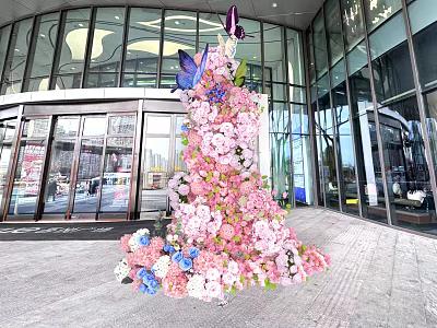 Art Installation Featuring Pink Blue White Flowers And Butterflies At Building Entrance With Glass Facade 3d model