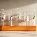 Modern Window Display With Orange Base And Five Glass Dome Stands Holding Colored Items