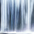 Person Sitting on Chair Facing Giant Flowing Water Curtain with Flowing Light on Ground