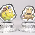 Two Colorful Cartoon Monster Figurines With Silver Speckled Bases Featuring MONSTER Text