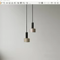 Two Modern Pendant Lights With Beige Shades And Black Metal Frames For Interior Decor