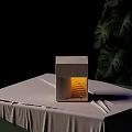Gray Cubic Wall Lamp With Warm Yellow Light And Green Plant Leaves On Dark Background