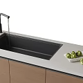 Kitchen Sink With Faucet Running Water Green Fruits On Light Colored Countertop Wooden Cabinets